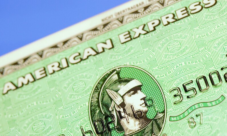 Detailansicht einer American Express Karte, die den markanten römischen Kopf in einem Kreis auf grünem Muster zeigt. | © IMAGO/Panthermedia