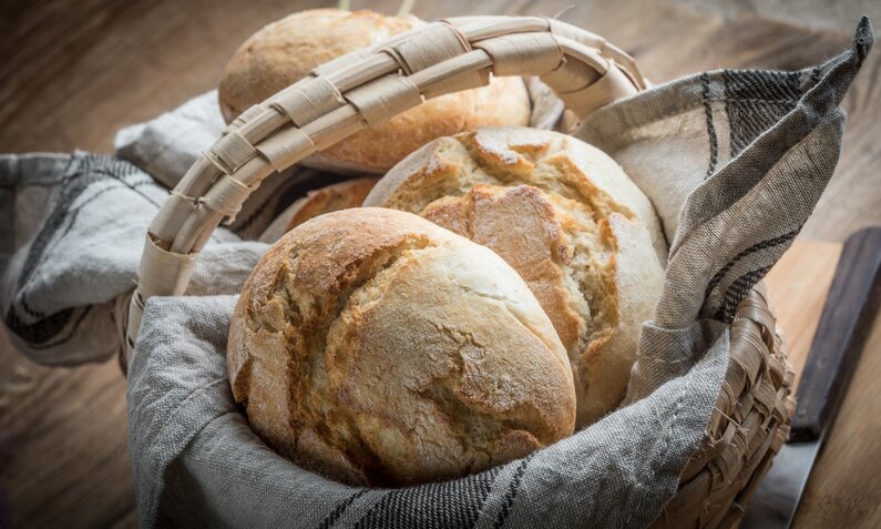 Goldig gebackene Ciabatta-Brötchen in Brotkorb mit Decke drinnen. | © Adobe Stock / Arkadiusz Fajer