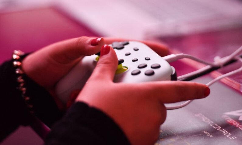 Hände halten einen Game-Controller | © Getty Images/Ina Fassbender