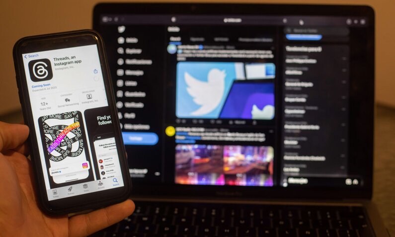 Smartphone mit Threads-Icon vor einem Tablet, auf dem das Twitter-Icon zu sehen ist. | © Getty Images/SOPA Images