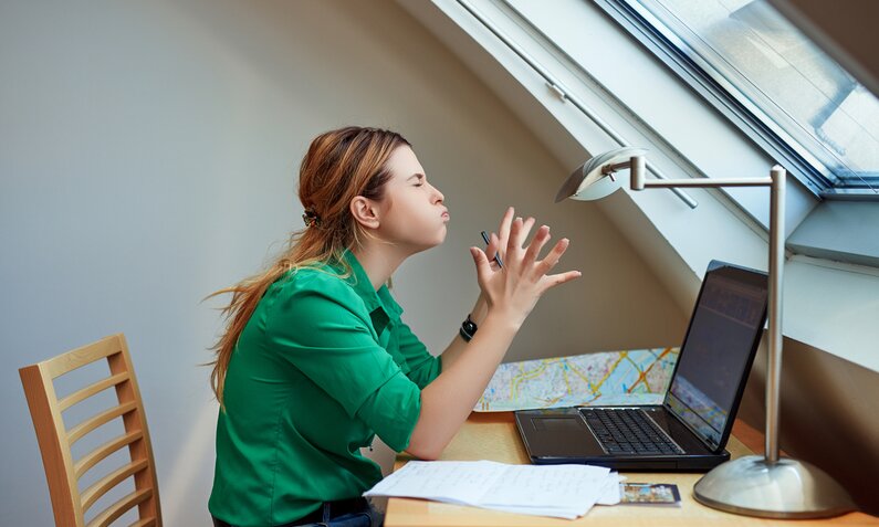 Junge Frau, Im Profil zu sehen, sitzt vor einem Laptop und ärgert sich sichtlich über etwas.  | © Getty Images/stock_colours