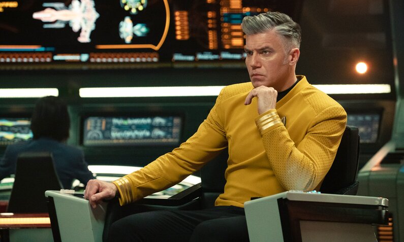 Anson Mount als Captain Christopher Pike in einer Szene aus "Star Trek: Strange New Worlds". Er sitzt auf der Brücke im Captainssessel, wir sehen ihn im Profil und  er blickt ernst in die Ferne. | © Paramount+