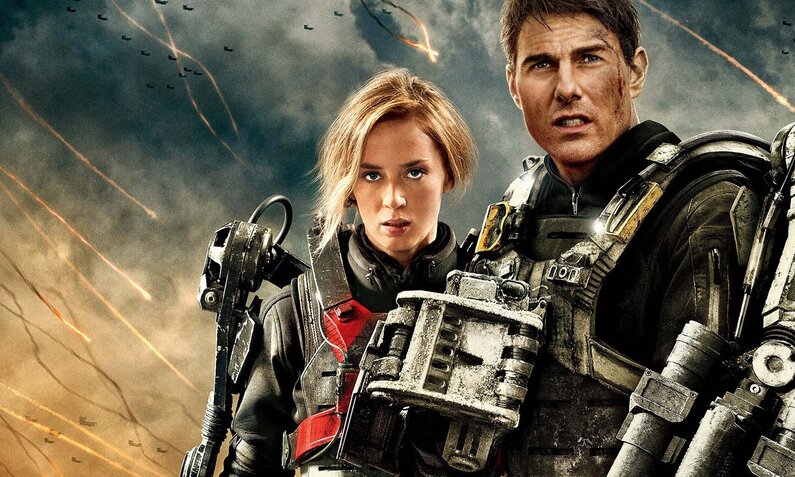 Emily Blunt und Tom Cruise stehen nebeneinander in futuristischen Rüstungen vor einem dramatische Himmel in einer Szene aus dem Kinofilm "Edge of Tomorrow" | © ddp images/Capital Pictures