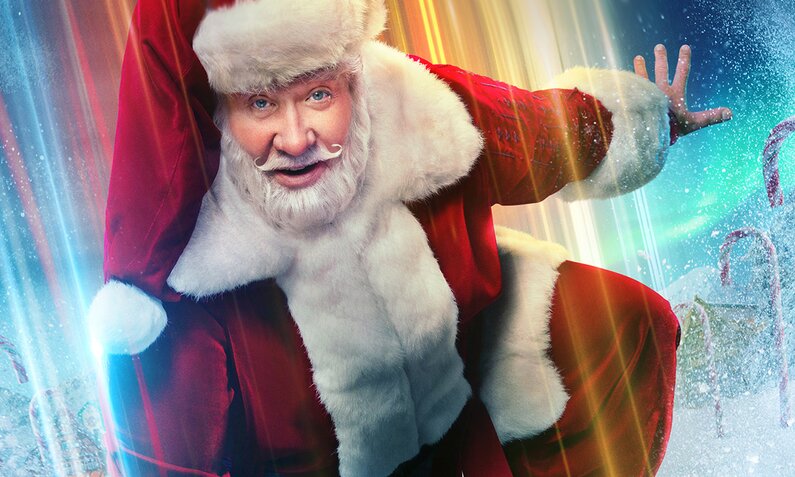 Tim Allen als Weihnachtsmann im roten kostüm und mit Mütze in dynamischer Pose vor Nordpool-Hintergrund auf der Key Art zur Disney+ Serie "Santa Clause: Die Serie" - Staffel 2 | © Disney+