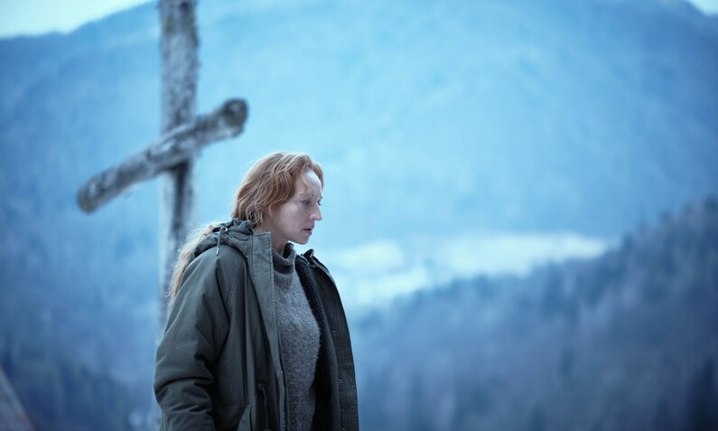 Brigitte Hobmeier in Winterkleidung vor einer Winter-Berglandschaft in einer Szene der Serie "Schnee" | © BR / NDR / ORF / Primary Pictures, Wien/X-Filme Produktion GmbH, Berlin / Martin Rattini und Oliver Oppitz 