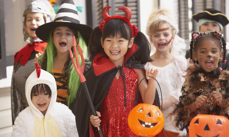 Kinder in verschiedenen Halloween Kostümen | © Getty Images / Ariel Skelley