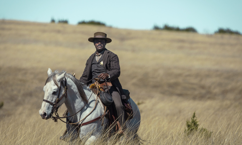 David Oyelowo reitet in einer Szene der Paramount+ Serie "Lawmen: Bass Reeves" durch eine Grassteppe. | © Paramount+