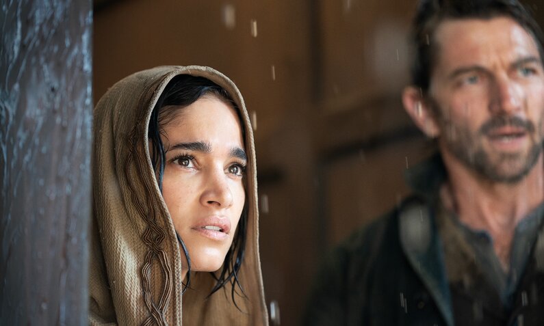 Nahaufnahme der Gesichter von Sofia Boutella als Kora and Michiel Huisman als Gunnar in einer Szene aus dem Netflix-Film "Rebel Moon" | © Netflix/Chris Strother