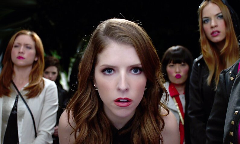 Nahaufnahme von Anna Kendrick als Bella in einer Szene aus dem Kinofilm "Pitch Perfect 2" - im Hintergrund ihre Freundinnen | © ddp images/LMKMEDIA