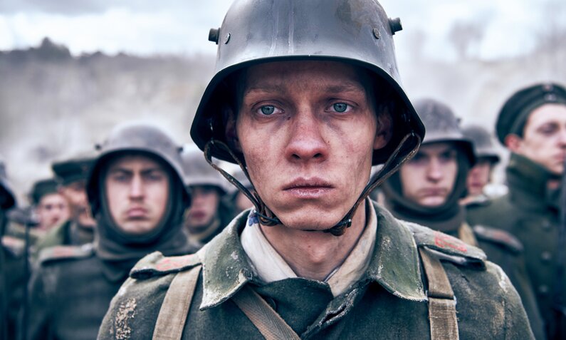 Felix Kammerer in Uniform und mit Helm im Schützengraben in einer Szene aus dem Netflix-Film "Im Westen nichts Neues" | © Netflix/Reiner Bajo