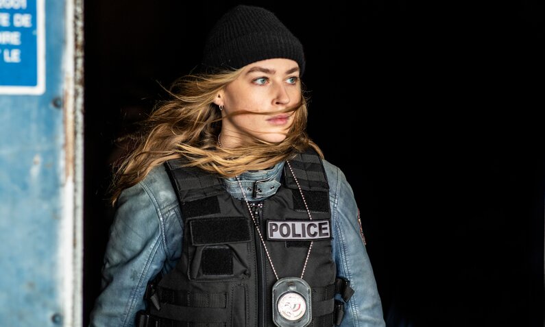 Jeanne Goursaud in Cop-Uniform kommt aus einer Tür in einer Szene der Netflix-Serie "Pax Massilia" | © Netflix/Laurent Le Crabe