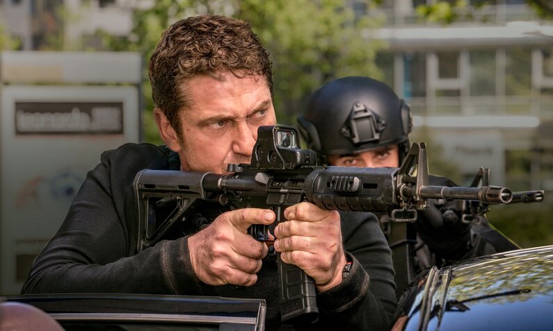 Gerard Butler als Secret Service Agent ist in einer Nahaufnahme im Vordergrund mit automatischer Waffe im Anschlag zu sehen in einer Szene aus dem Film "Angel has fallen" - im Hintergrund eine weitere Agentin  | © ddp images/LMKMEDIA