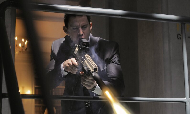 Channing Tatum feuert mit einer automatischen Waffe nach unten über ein Geländer in einer Szene des Kinofilms "White House Down" | © Imago Images/Mary Evans