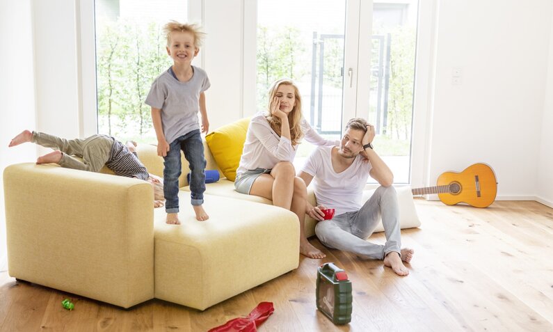 Eine Familie im Wohnzimmer | © Getty Images / Westend61
