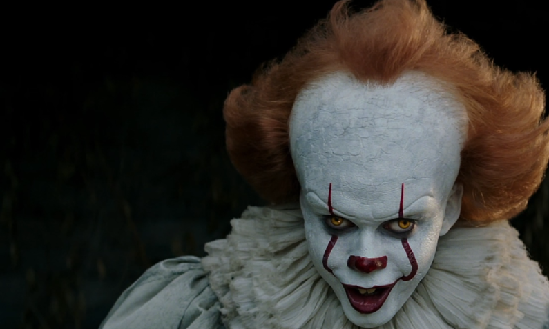 Der Horror-Clown Pennywise mit weiß geschminktem Gesicht, roten Lippen und abstehenden Haaren. | © Amazon