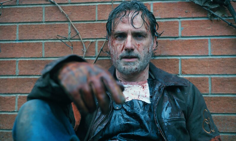 Nahaufnahme von Andrew Lincoln als Rick Grimes, der in einer Szene der Serie "The Walking Dead: The Ones Who Live" erschöpft an einer Backsteinmauer lehnt. | © Magenta TV/AMC