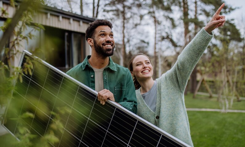 Zwei Personen haben ein Solarmodul in der Hand | © Getty Images/Halfpoint Images