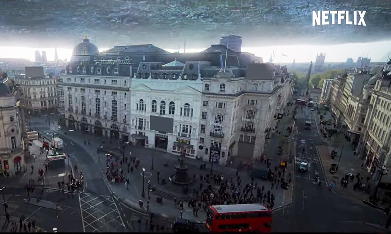 Auf dem Screenshot aus dem Trailer zur Netflix-Serie "3 Body Problem" ist eine Straße in einer Stadt mit hohen alten Häusern zu sehen über der ein riesiges Raumschiff zu schweben scheint. | © Netflix/Screenshot Trailer auf YouTube