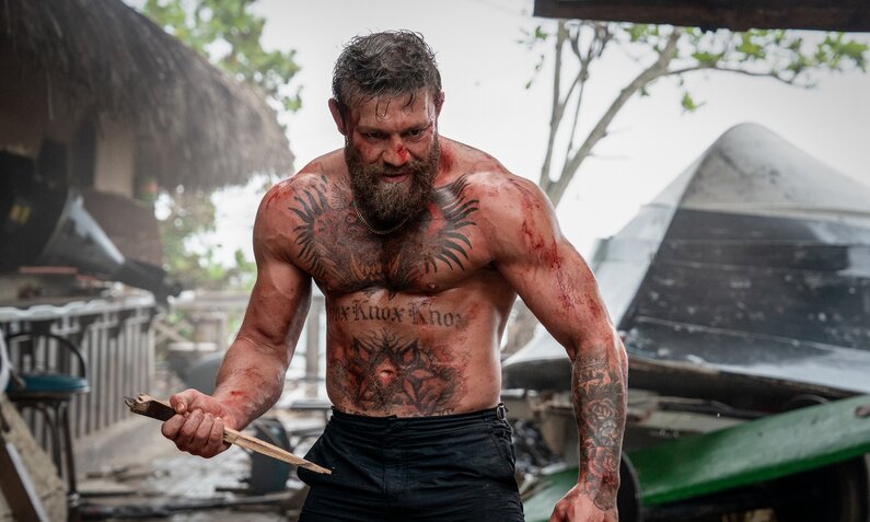 Conor McGregor steht kampfbereit und furchteinflößend da in einer Szene aus dem Prime Video Film "Road House" | © Amazon Prime Video