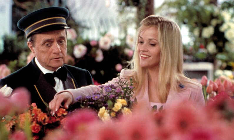 Bob Newhart und Reese Witherspoon begutachten in einer Szene aus dem Kinofilm "Natürlich blond 2" verschieden Blumen in einem Blimenladen | © Imago Images/Everett Collection