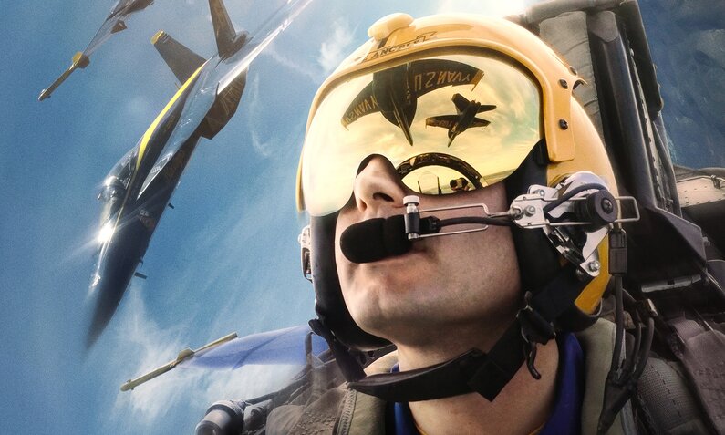 Nahaufnahme eines Navy-Piloten mit Helm und spiegelnder Brille in der Kanzel seines Jets auf der Key Art zur Prime Video Doku "The Blue Angels" | © Amazon/IMAX/MGM