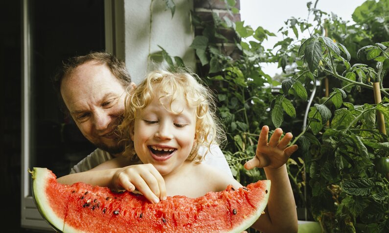 Vater und Sohn mit Melonenspalte | © Getty Images/ Westend61