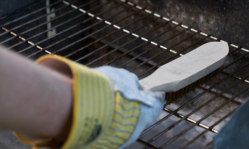 Grillrost wird mit Bürste gereinigt | © Getty Images/ In Stock