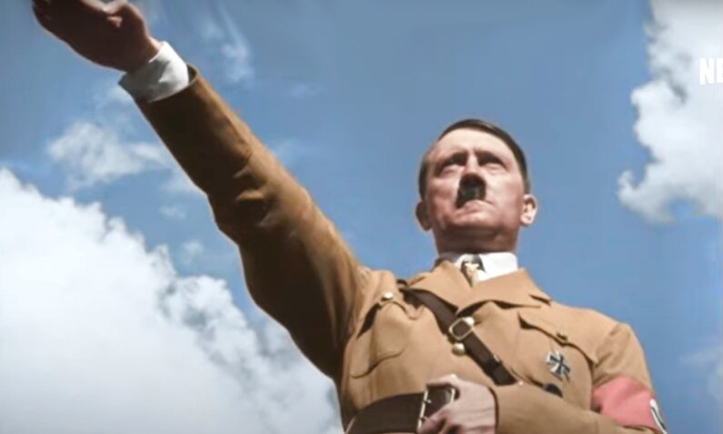 Hitler mit zum Hitlergruß erhobenen Arm vor blauem Himmel in einem Screenshot aus dem Trailer zur Netflix-Dokuserie "Hitler and the Nazis: Evil on Trial " | © Netflix