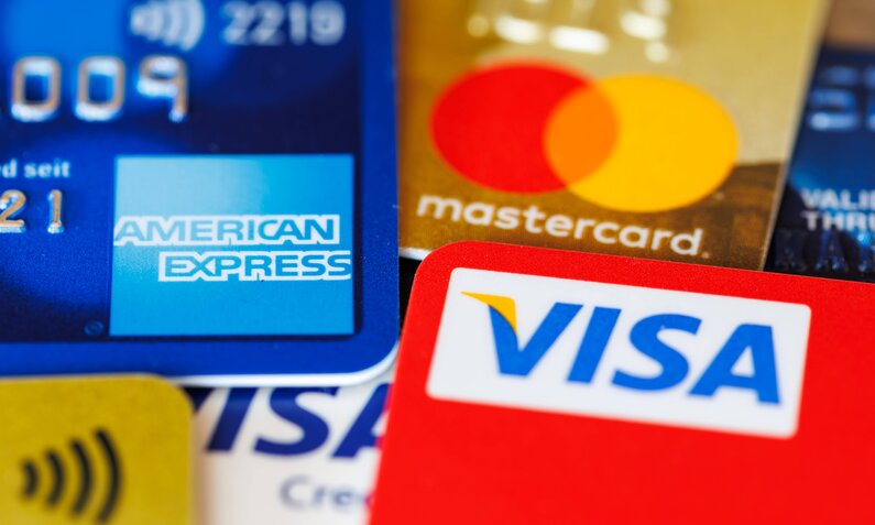 Nahaufnahme verschiedener Kreditkarten von American Express, Mastercard und Visa in unterschiedlichen Farben. | © IMAGO/Aviation-Stock