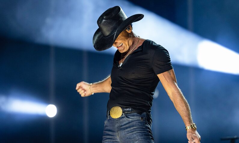 Tim McGraw steht bei einem Konzert in Nashville auf der Bühne in schwarzem Shirt, Cowboyhut und Jeans in ausdrucksstarker Pose | © Imago Images/ZUMA Wire