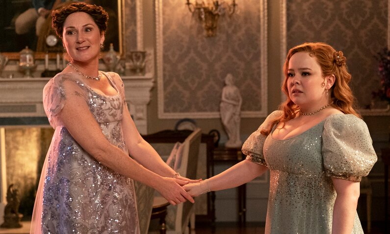 Ruth Gemmel als Lady Bridgerton und Nicola Coughlan als Penelope Feathertington halten sich an den Händen in einer Szene der dritten Staffel von "Bridgerton" | © Netflix/Liam Daniel