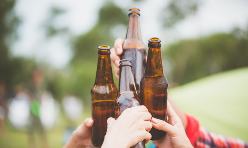 Leute stoßen mit Bierflaschen an | © Adobe Stock/ tirachard