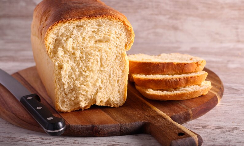 Angeschnittener Laib Weißbrot / Toastbrot auf Holzbrett. | © Getty Images / Bildnachweis:	manyakotic