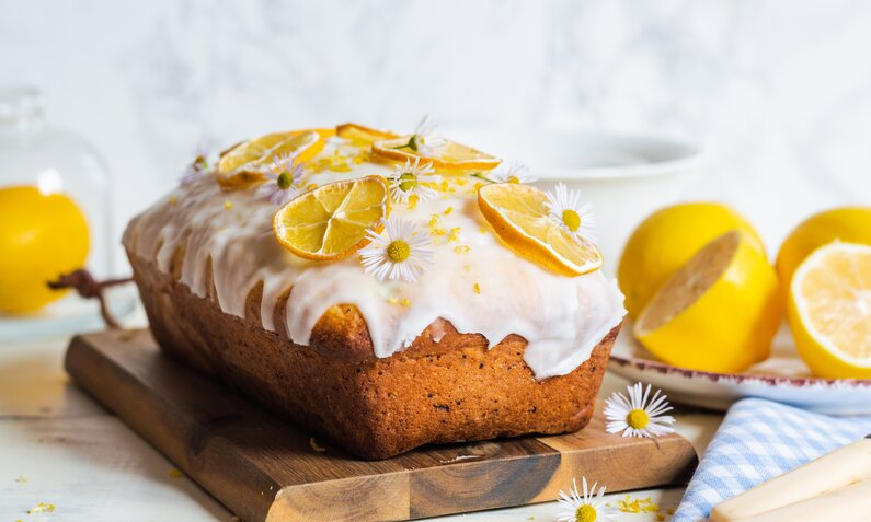 Joghurtkuchen mit Zitronenglasur auf einem Brett angerichtet. | © Getty Images / Rome2015