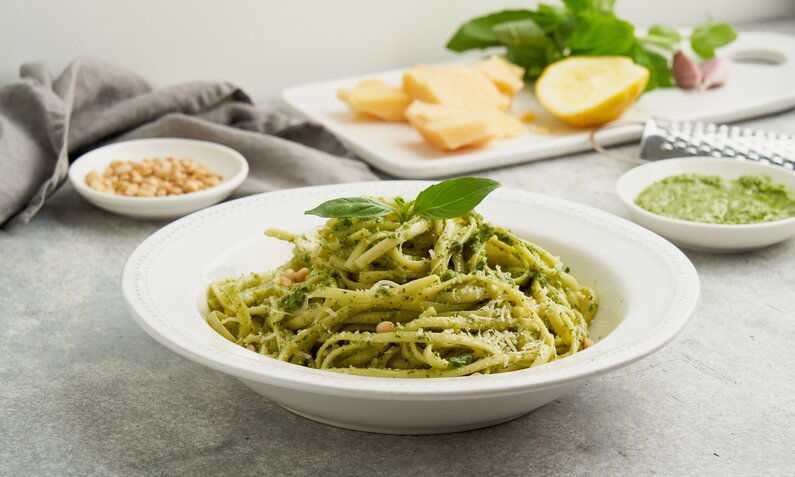 Aufgedrehte hausgemachte Pasta auf weißem Pasta-Teller, in grünem Pesto. | © Getty Images / Natalia Gdovskaia