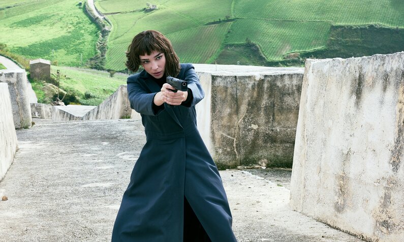 Matilda De Angelis steht als Agentin Diana mit gezogener Waffe in einer Auffahrt in einer Szene aus der Prime Video Serie "Citadel: Diana" | © Prime Video/Marco Ghidelli