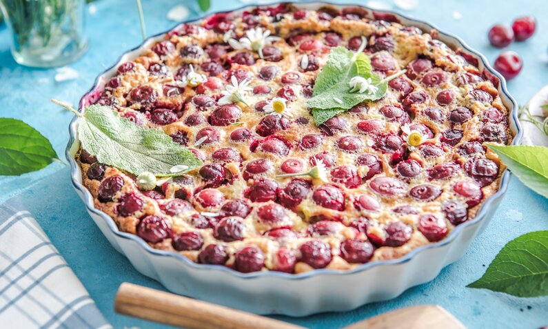 Kirsch-Joghurtkuchen in Backform in sommerlicher Athmosphere. | © Adobe Stock / Maria