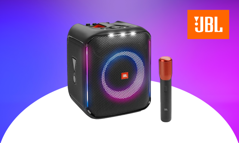 JBL Partybox Encore: Schwarzer Würfel mit pinken Lichtern, daneben ein Mikrophon | © Amazon/JBL