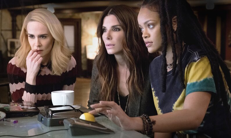 Sarah Paulson, Sandra Bullock und Rihanne blicken gespannt auf einen Computermonitor in einer Szenenbild aus dem Kinofilm "Ocean's 8" | © ddp images/LMKMEDIA